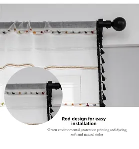 Detail of white sheer curtain with colorful wave embroidery and black tassel edges