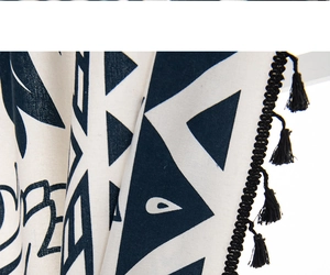 Close-up of cotton linen curtain fabric with geometric print and black tassels