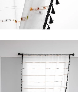 Detail of white semi-sheer curtain with colored dot embroidery and black tassel edge
