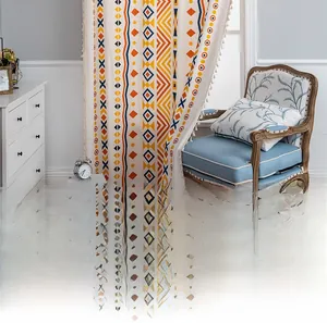Detail of bohemian cotton linen curtain featuring geometric patterns and white tassels