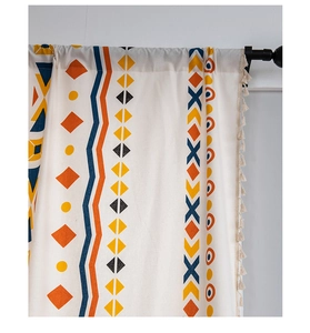 Detail view of Bohemian curtain fabric with geometric prints and tassel trim