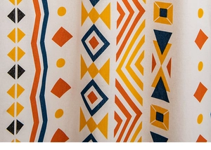 Close-up of bohemian geometric printed fabric with vivid orange and blue patterns