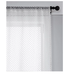 Dettaglio della tenda trasparente bianca con texture a pois su un bastone nero