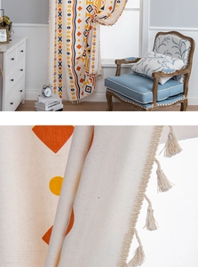 Detail of bohemian cotton linen curtain showing geometric prints and beige tassels fringe