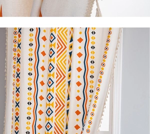 Detail of bohemian geometric print curtain with cotton linen texture and fringe trim