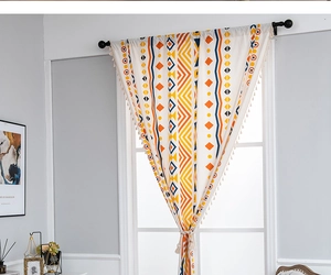 Detail of bohemian cotton linen curtain with geometric prints and white tassel fringe