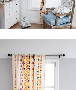 Close-up of bohemian linen curtains with geometric patterns and white fringe trim