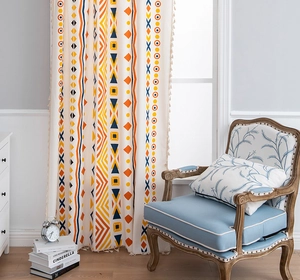 Detail of bohemian cotton linen curtain with colorful geometric patterns and elegant tassels