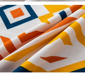 Close-up of geometric printed linen cotton fabric with vibrant orange and blue patterns