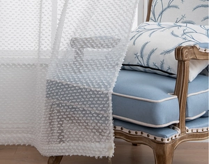 Dettaglio della tenda bianca semitrasparente con trama a rilievo 3D con punti pom-pom