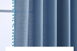 Detail eines hellblauen Vorhangs mit Leinentextur und dekorativem Bommelsaum