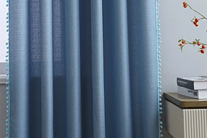 Blauer Leinenvorhang mit dekorativer Bommelborte für kleine Fenster im Detail