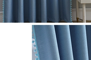 Detailansicht der graublauen Vorhangtextur mit dekorativen Pom-Pom-Fransen am Rand