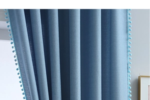 Detail von blauem Vorhangstoff mit dekorativer Borte aus passenden Bommelfransen