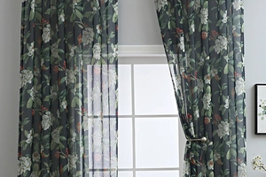 Detailed close-up of dark grey floral semi-sheer curtain with elegant metal ball tieback
