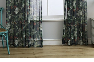 Detail of floral printed linen curtain with semi-sheer white flowers and green leaves
