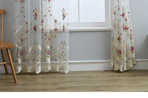 Detailed embroidery of red and yellow flowers on white sheer curtains with lace hem