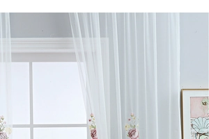 Close-up of elegant white sheer curtain featuring delicate rose floral embroidery details
