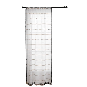 White semi-sheer curtain with black tassel fringe and yellow striped embroidery