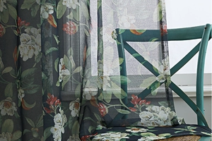 Detail of vintage floral print on semi-sheer cotton linen curtain with green leaves