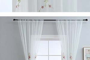 Detailed close-up of pink and purple floral embroidery on white semi-sheer tulle curtains