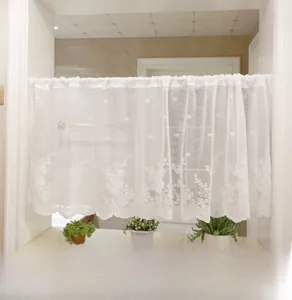 Detailed view of white floral lace cafe curtain with delicate hollow embroidery and wavy edge