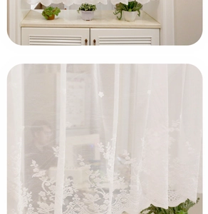 Detailed view of white floral lace sheer curtain with scalloped edges and floral embroidery