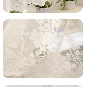 Detailed close-up of white floral lace curtain fabric with elegant crochet embroidery pattern