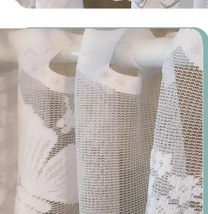 Detailed macro view of white floral lace curtain mesh with rod pocket suspension