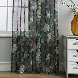 Dark grey floral sheer curtain with white flowers and green leaves in a bright room