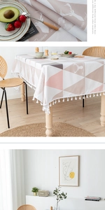 Détail de nappe nordique en PVC avec triangles roses, motif élan et pompons blancs
