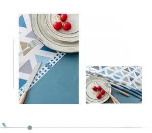 Macro detail of Nordic geometric PVC tablecloth with blue triangle pattern and hollow lace edge