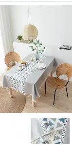 Detail of Nordic grey PVC tablecloth with geometric triangles and white tassels