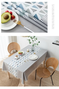 Detail of Nordic grey tablecloth featuring geometric patterns and cream tassel edges
