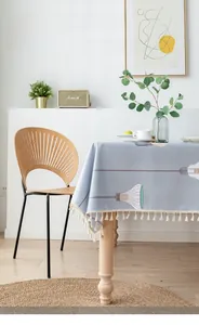 Detail of grey-blue cotton linen tablecloth with lamp prints and beige tassels