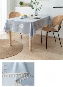 Detail of light blue Nordic PVC tablecloth with tassel fringe and white bulb print