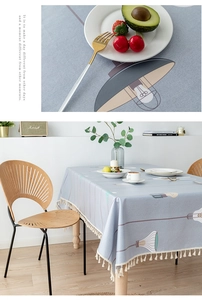 Detail of light blue-grey PVC tablecloth with modern chandelier print and white tassels