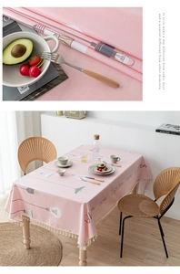 Close-up of pink PVC tablecloth with hand-drawn patterns and elegant cream fringe edge