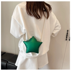 Star-shaped green acrylic crossbody bag with a gold chain strap shown on a model