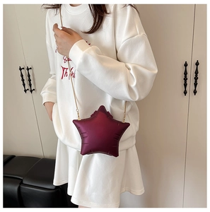 Close-up of star-shaped crossbody bag in wine red PU leather with gold chain strap