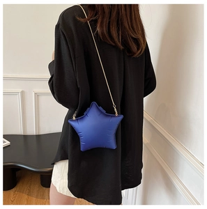 Detail of blue star-shaped crossbody bag with quilted matte texture and gold chain