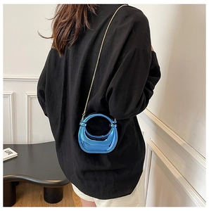 Detalle del bolso de luna azul metálico con acabado de espejo galvanizado y cadena dorada