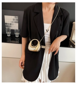 Chic metallic acrylic mini bag with gold chain strap worn with a stylish outfit