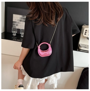 Mini bolso bandolera rosa metalizado con asa circular y cadena dorada en modelo