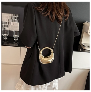 Mini bolso de silla dorado pulido con cadena de acrílico y asa redonda mostrado en modelo