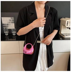 Detailed view of glossy metallic rose pink mini crescent bag with fine chain strap