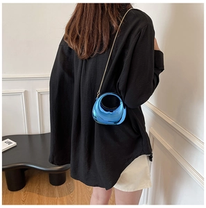 Chic blue mirror acrylic mini bag styled as a crossbody with a fine gold chain strap