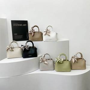 Chic soft leather bucket bags in multiple colors with decorative scarves on a display