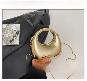 Detail of gold mirror finish mini bag with unique hollow egg shape and chain strap