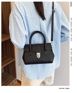 Détail du sac Boston en cuir grainé noir avec fermoir rotatif argenté et bandoulière